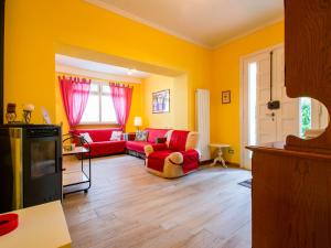 una sala de estar con paredes amarillas y muebles de color rojo. en Apartment Matteo by Interhome, en Avaglio
