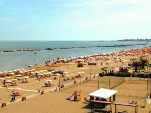 ein Strand mit vielen Sonnenschirmen und Menschen in der Unterkunft Apartment Carioca by Interhome in Rimini