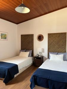 a bedroom with two beds and a wooden ceiling at Horta do Monte in Estremoz +37 photos