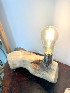 a light on a wooden beam with a light bulb on it at La Francisca II in Formosa
