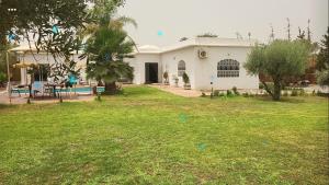 une maison blanche avec une cour devant elle dans l'établissement Villa Dar Sukar, à Marrakech