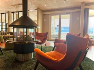 eine Lobby mit Stühlen und einem Kamin in einem Zimmer in der Unterkunft Ryfylke Fjordhotel in Sand