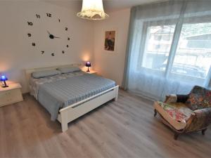 um quarto com uma cama e um relógio na parede em Apartment La Casa di Lara by Interhome em Morbegno