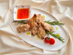 a plate of food with meat and a dipping sauce at Frankfort Hotel and Spa in Tashkent