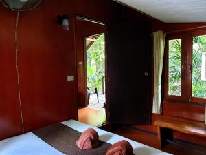 a bedroom with a bed with two slippers on it at Khao Sok Cabana Resort in Khao Sok