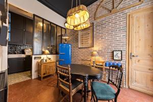 a kitchen with a table and chairs and a brick wall at Les Petites Suites Dieppoises - La Demeure de Peau d'Ane in Dieppe