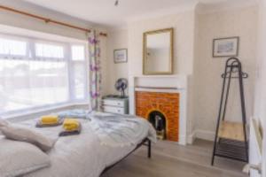 a bedroom with a bed and a fireplace and a ladder at Lanehouse Rocks in Weymouth