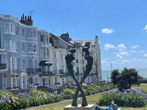 a statue in front of some buildings and the ocean at Studio room in Brighton city centre in Brighton & Hove