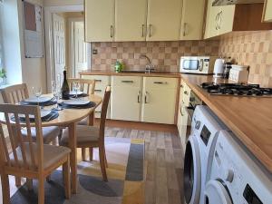 a kitchen with a table and chairs and a kitchen with a stove at Plymouth Hoe Central * Free Parking * Ocean Reach in Plymouth