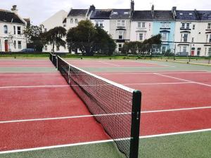 a tennis net on a tennis court in front of buildings at Plymouth Hoe Central * Free Parking * Ocean Reach in Plymouth