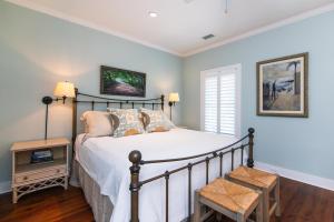 ein Schlafzimmer mit einem Bett, einem Stuhl und einem Fenster in der Unterkunft Creekside Cottage in Edisto Island