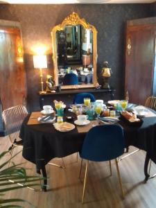 un tavolo con cibo e uno specchio in una stanza di La Ménardière Serenitatis chambre d'hôtes petit déjeuner compris a Corseul