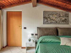 um quarto com uma cama verde e uma porta de madeira em Apartment Azalea by Interhome em Lucino