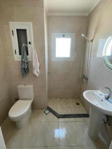 uma casa de banho com um WC e um lavatório em شاليه الزمردة بمنتجع سانتوريني em El Alamein