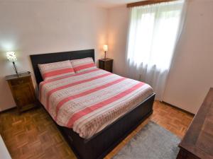 ein Schlafzimmer mit einem großen Bett und einem Fenster in der Unterkunft Apartment Isola di Madesimo Apartments-2 by Interhome in Isola