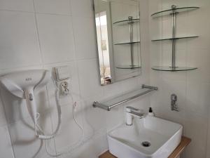 La salle de bains blanche est pourvue d'un lavabo et d'un miroir. dans l'établissement Stawy u Sikory. Agroturystyka i łowisko, à Nowa Wieś