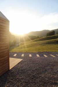 a room with a view of a field with the sun shining at Hiška-Glamping in Ajdovščina