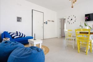 - un salon avec un canapé bleu et des fauteuils jaunes dans l'établissement Villa Chiara, à Lecce