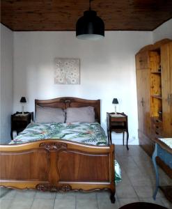a bedroom with a wooden bed and two night stands at Le grenier d'Emma in Langeac