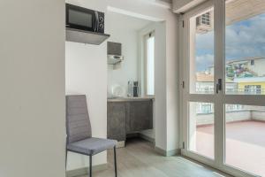 a living room with a chair and a balcony at Residence Velò - Bike & Family in Giulianova
