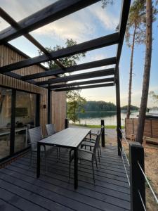 a picnic table on a deck with a view of a lake at Tiny House - Osada Wilkasy in Giżycko