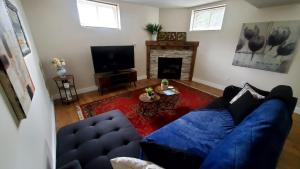 un soggiorno con un divano blu e un camino di Spacious Guest Suite a Hamilton