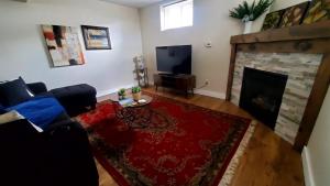 a living room with a couch and a fireplace at Spacious Guest Suite in Hamilton