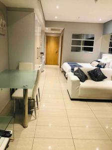 - un salon avec un canapé et une table dans l'établissement Stunning sea facing apartment, à Durban