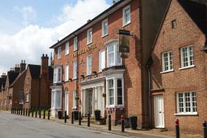 a row of brick buildings on a street at The Bell Hotel Woburn By Greene King Inns in Woburn