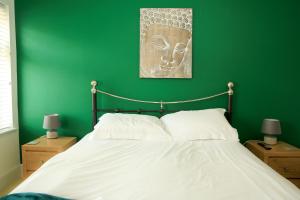 - une chambre avec un mur vert et un lit dans l'établissement Myana Nest - Walking Distance to Pakefield Beach, à Lowestoft