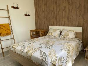 1 dormitorio con cama con edredón blanco y escalera en Villa individuelle - CHASSIEU en Chassieu