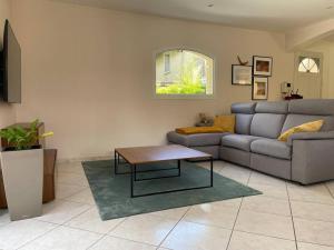 a living room with a couch and a coffee table at Villa individuelle - CHASSIEU in Chassieu