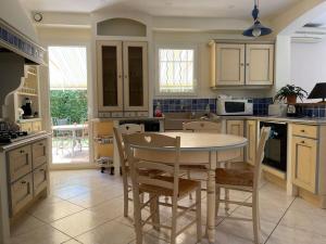 a kitchen with a table and chairs in it at Villa individuelle - CHASSIEU in Chassieu
