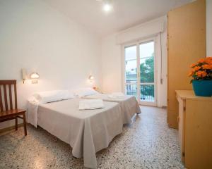 - une chambre avec un grand lit blanc et une fenêtre dans l'établissement HOTEL BLUE SKY, à Rimini