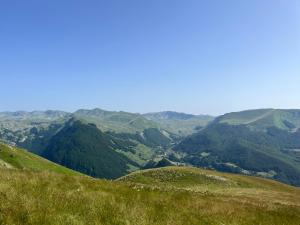 vistas a una colina verde con montañas en el fondo en Jezerina en Šavnik