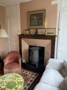 a living room with a couch and a fireplace at Maison individuelle dans un parc in Pontchardon