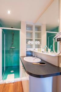 a bathroom with a sink and a shower at HOTEL CERISE - LES SOURCES Luxeuil-les-Bains in Luxeuil-les-Bains