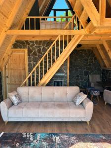 un soggiorno con divano sotto una scala in legno di Oruba bungalov a Rize