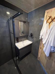 ein Bad mit einem Waschbecken und einem Spiegel in der Unterkunft Oruba bungalov in Rize