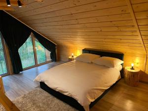 a bedroom with a bed in a wooden cabin at Krasne Residence & SPA - STREFA CISZY in Krasne