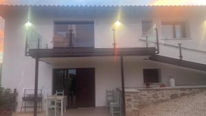 a white house with a balcony and a patio at Apartamentos rurales La Teyeruca I in Acebal