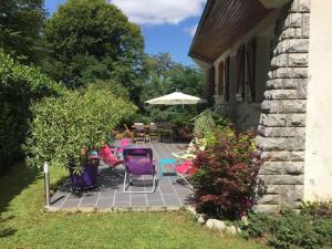 a patio with chairs and an umbrella in a yard at Grande maison confortable à Bagnères in Bagnères-de-Bigorre