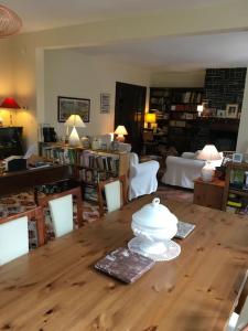 a living room with a wooden table and a library at Grande maison confortable à Bagnères in Bagnères-de-Bigorre