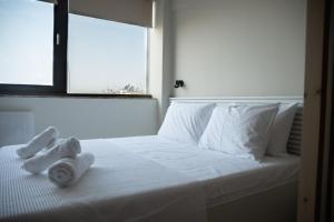 a white bed with towels on it with a window at DOWNTOWN STUDIO in Thessaloniki