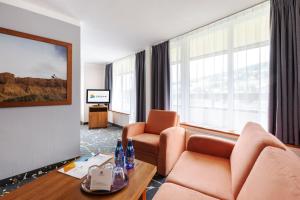 シフィエラドゥフ・ズドルイにあるInterferie Aquapark Sport Hotel Malachitのソファ、椅子、テレビが備わるホテルルームです。