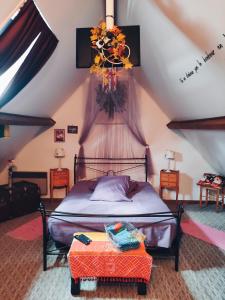 Montmirail的住宿－La Désirade，一间卧室配有一张床和一张鲜花桌子