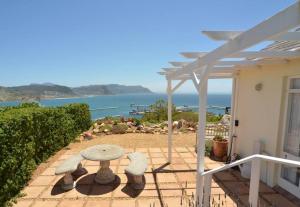 un patio con mesa y vistas al océano en Spectacular views Simonstown, en Ciudad del Cabo