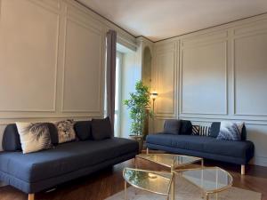 a living room with two blue couches and a glass table at Appartme Stampa 1 in Milan