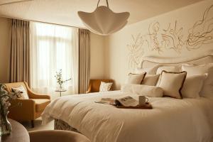 a bedroom with a large white bed and a chair at No 42 by GuestHouse, Margate in Margate