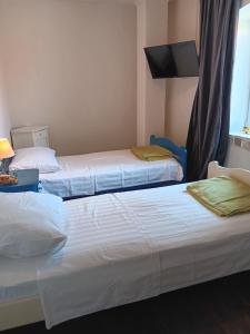 2 łóżka w pokoju hotelowym z oknem w obiekcie Family house w Hvarze